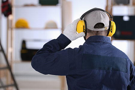 A worker wearing ear muffs