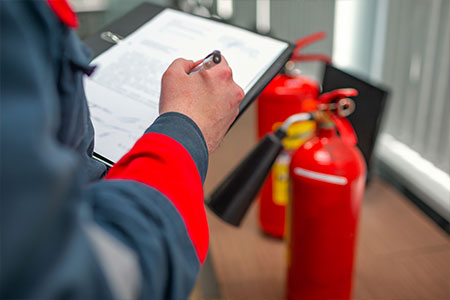 A fire marshal checking fire extinguishers