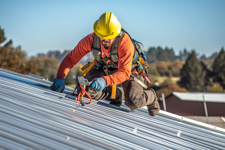 A construction worker on a roof wearing a harness