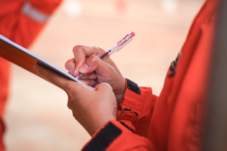 A person writing on a clipboard