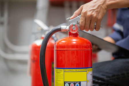 A person testing a fire extinguisher