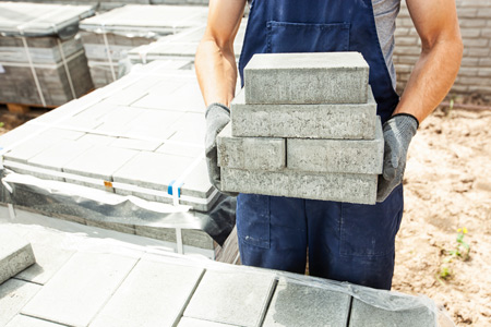 A man holding a pile of bricks