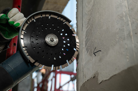 Person using a diamond abrasive wheel on a wall