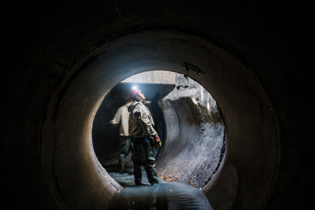 Construction workers in a sewage pipe