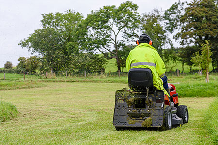 A man driving a ride on mower